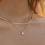 A close-up of a woman’s neck wearing LLUME Jewelry’s Vacation Capsule Set: one sleek chain and one delicate chain with a square stone pendant—perfect for stacking and elevating any jewelry look.