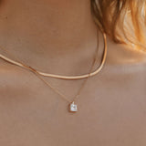 A close-up of a woman’s neck wearing LLUME Jewelry’s Vacation Capsule Set: one sleek chain and one delicate chain with a square stone pendant—perfect for stacking and elevating any jewelry look.
